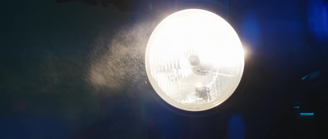 Dust particles floating in front of the headlight of a motorcycle at night