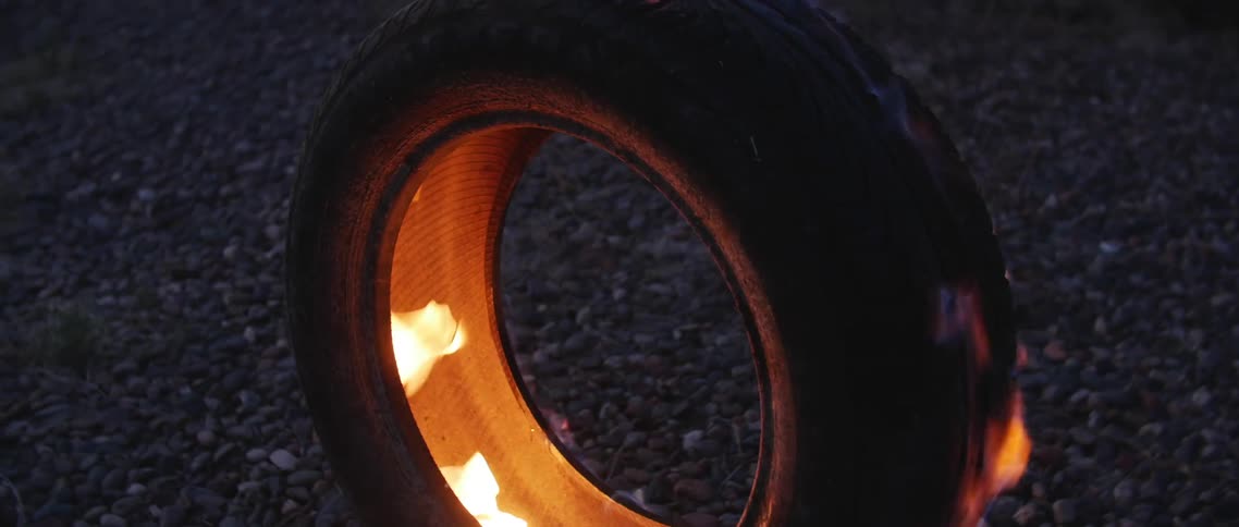 A rubber car tire is in flames