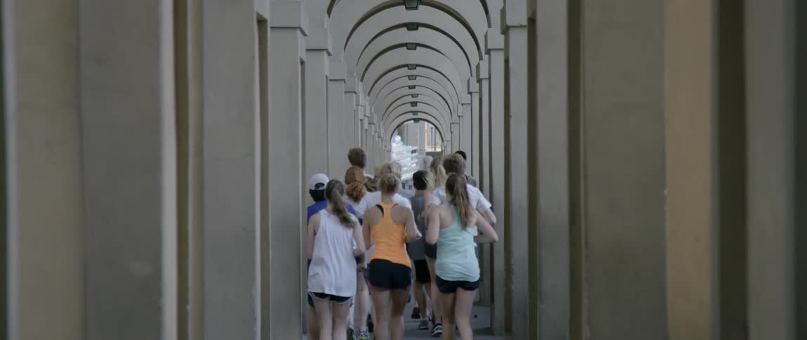 A group of people run under arches