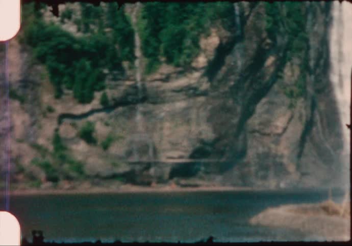 A large waterfall flowing over a cliff in the wilderness