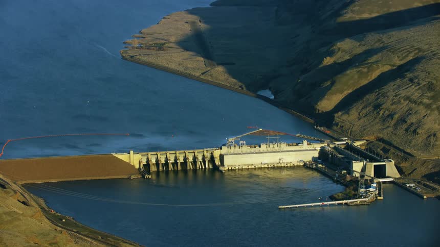 Lower Monumental Dam on the Lower Snake River in this high altitude aerial in golden hour light revealing the impoundment spanning the Army Corp of Engineers Dam