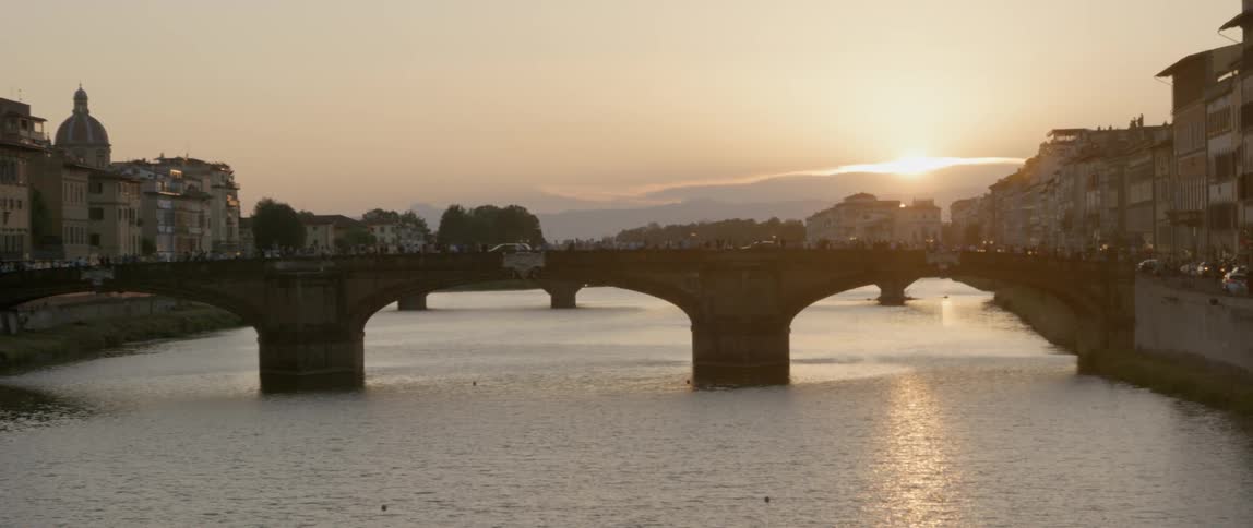 A bridge in paris as the sun sets behind it
