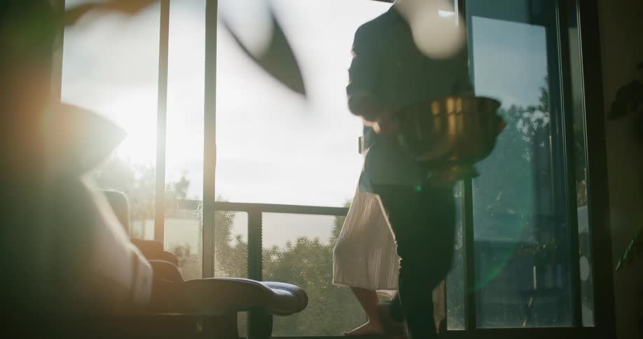 Pregnant woman stands on the balcony looking at the horizon