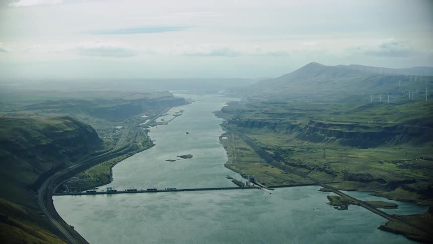 Center framed super wide high altitude aerial of the Lower Columbia River and the John Day Dam with Hydro Electric and Wind Power in the same frame