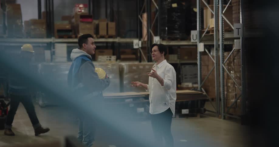 A man and woman talking in a warehouse