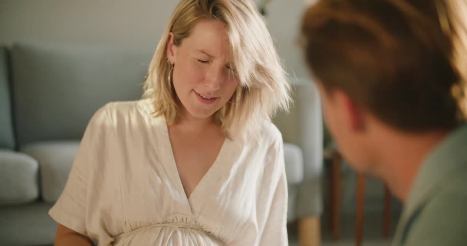Pregnant woman winces in pain