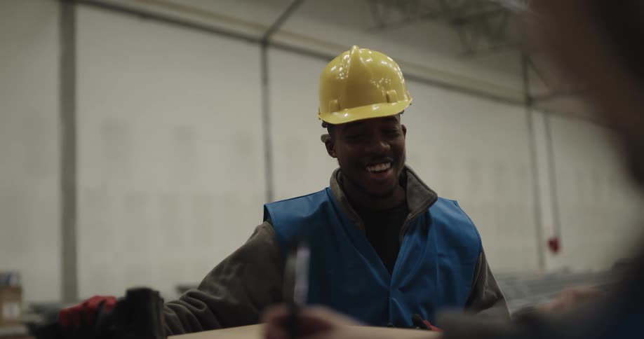 Warehouse worker talking to a coworker and using a walkie talkie
