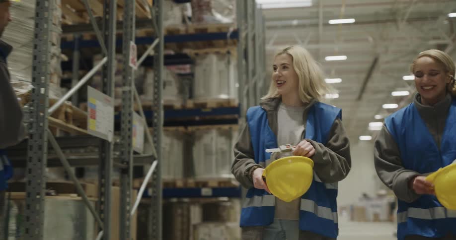 Three coworkers are talking in a warehouse