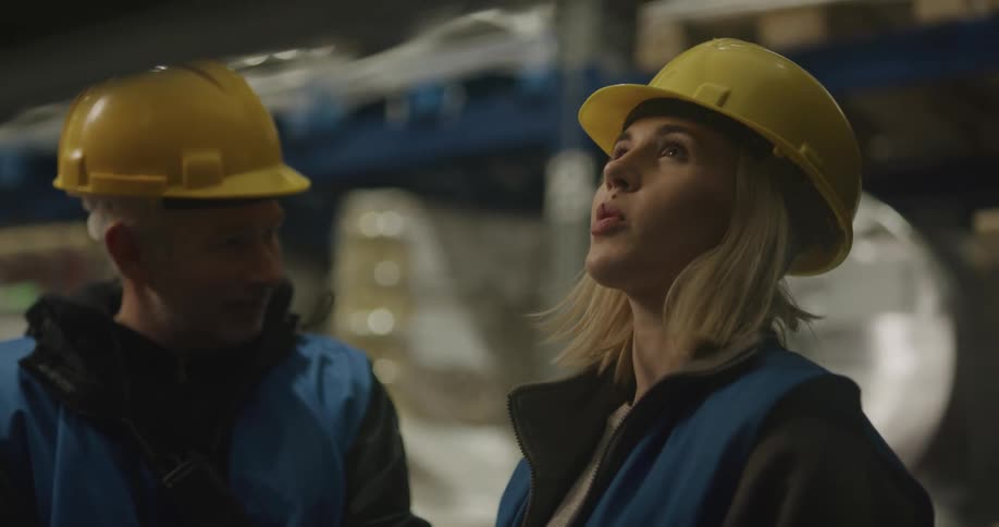 Two coworkers are talking by the inventory