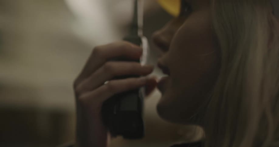 Female worker wearing a yellow hardhat talking on a walkie talkie