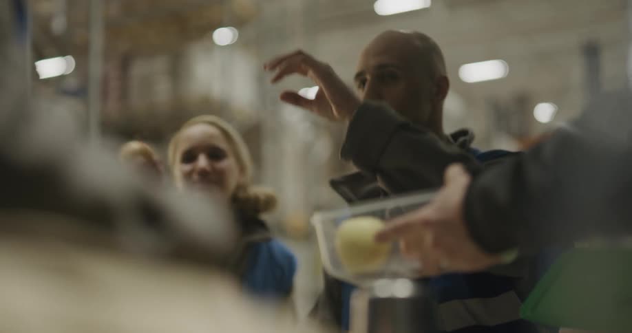 A group of coworkers sharing apples in a warehouse