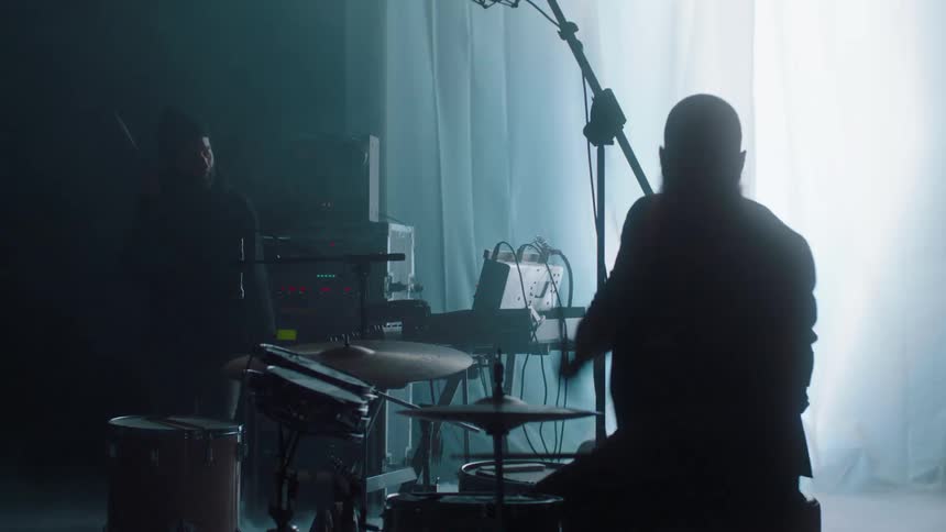 Musicians performing in a dark stage in front of strobing lights