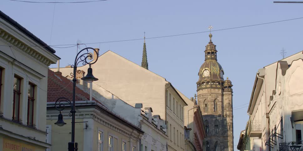 A village center in an old town with a gothic cathedral clock tower