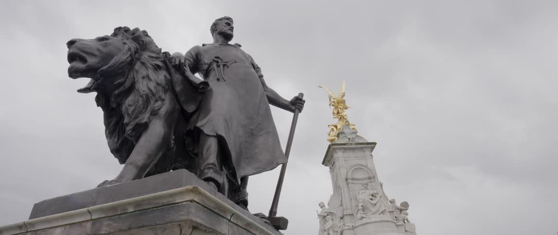Statue of a man and lion sit on top of a pillar