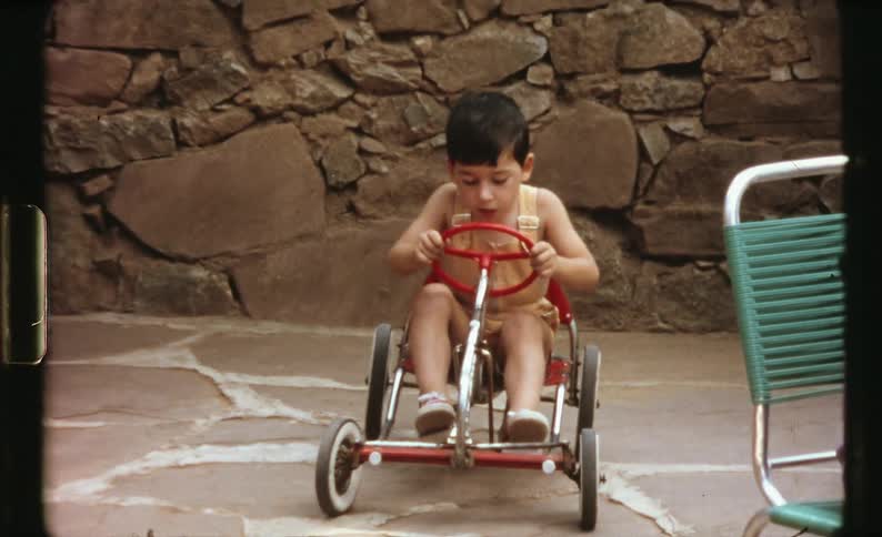 A child riding a pedal car outdoors
