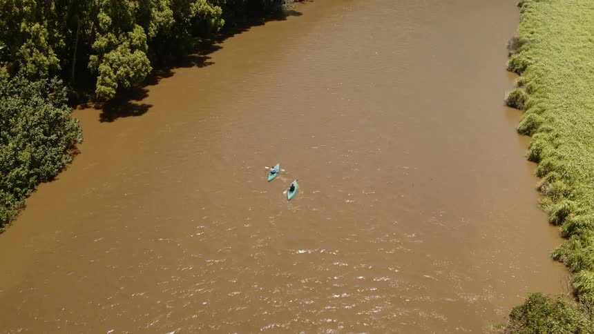 The two canoes are racing in the water below