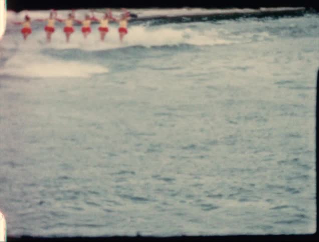 Water ski show attraction in a water park presented to a crowd caught on vintage film