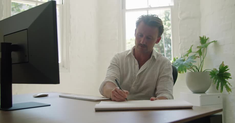 Man sitting in office video calling makes notes