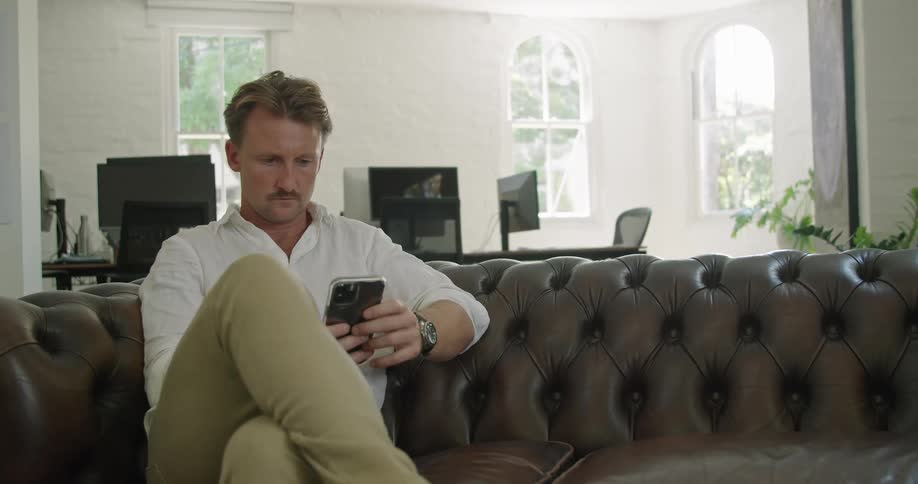 A man that is looking at something on a smartphone