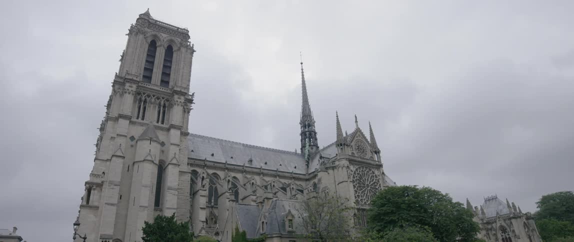 A large stone church sits under a cloudy sky