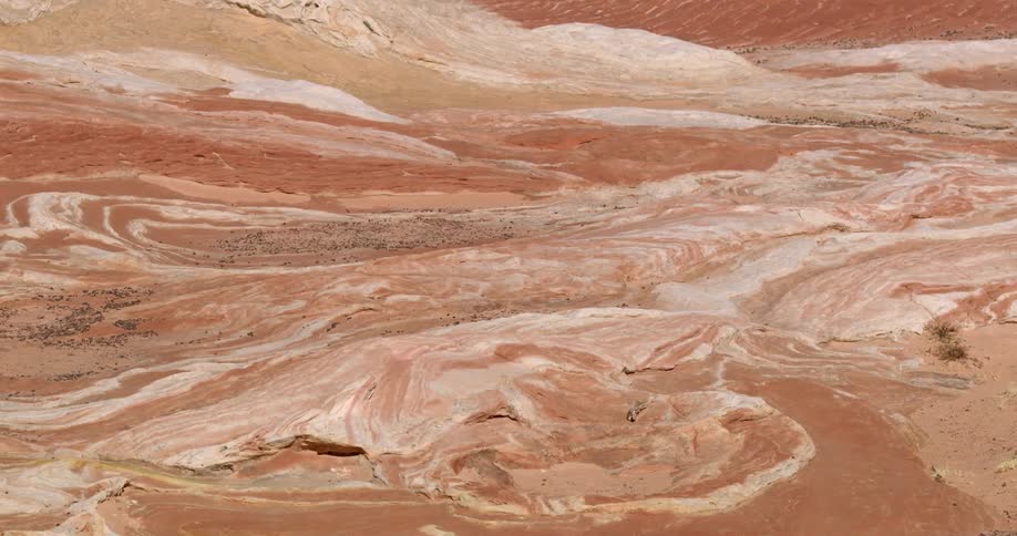 Sand covers the ground packed down into small hills striped with hues of brown