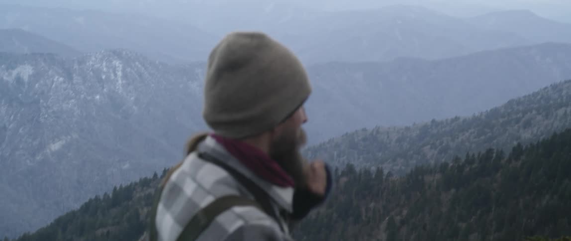 Man In Mountain Log Cabins During Winter
