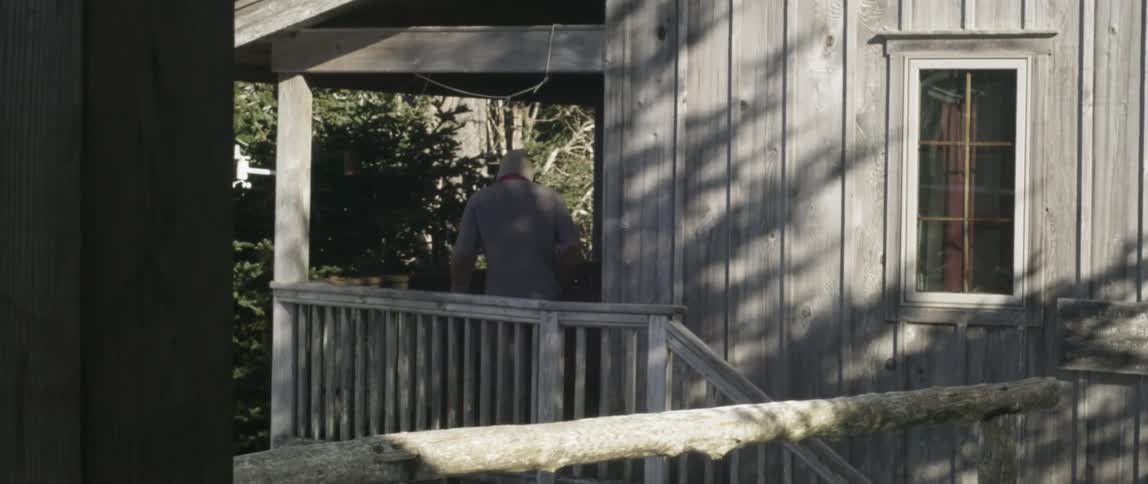 Man In Mountain Log Cabins During Winter