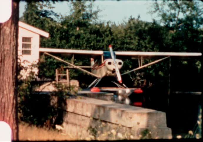 A docked Pontoon Plane is captured on vintage 8mm