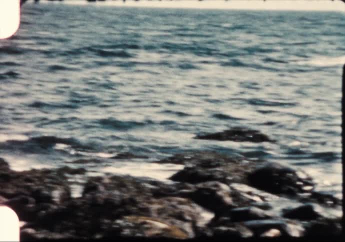 A rocky coast with waves with the sky and clouds in the background