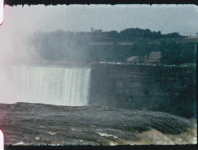 A vintage film of a waterfall crashing over a cliff