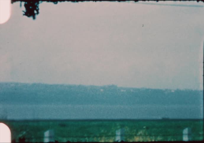 Lake and mountains near a house in a rural road caught on vintage film