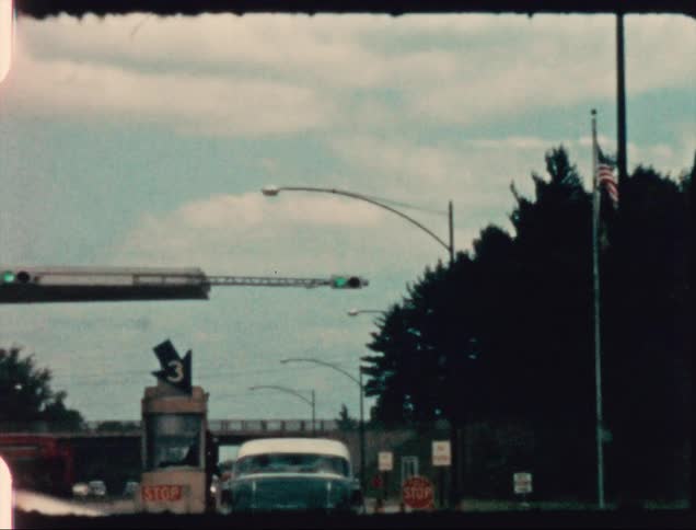 Cars driving and going through a toll booth