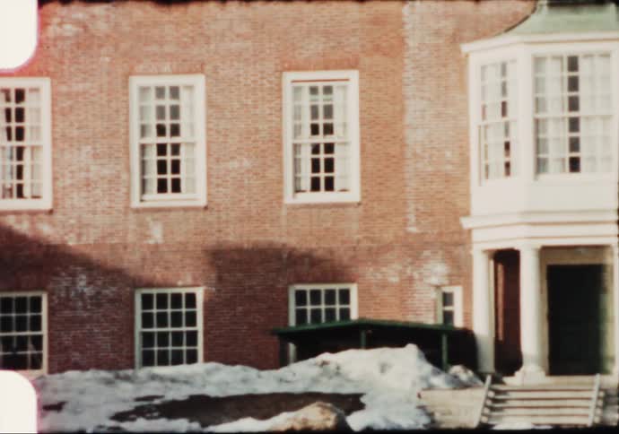 The facade of a pair of large brick buildings on a winter day