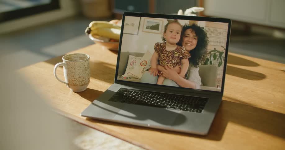 A woman and child talking on a laptop