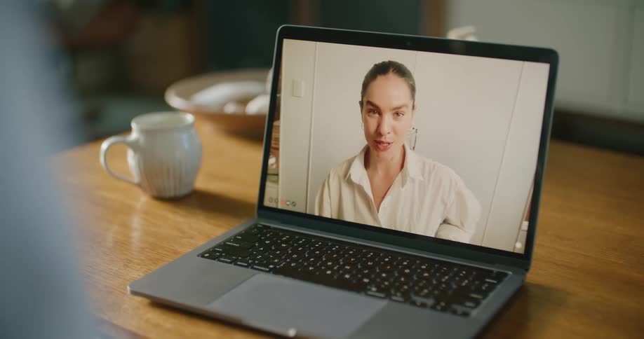 Person consults with female medical personnel over laptop