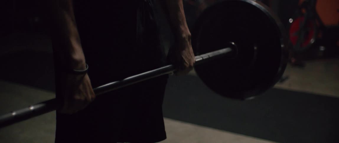 A man is lifting a heavy weight in the gym