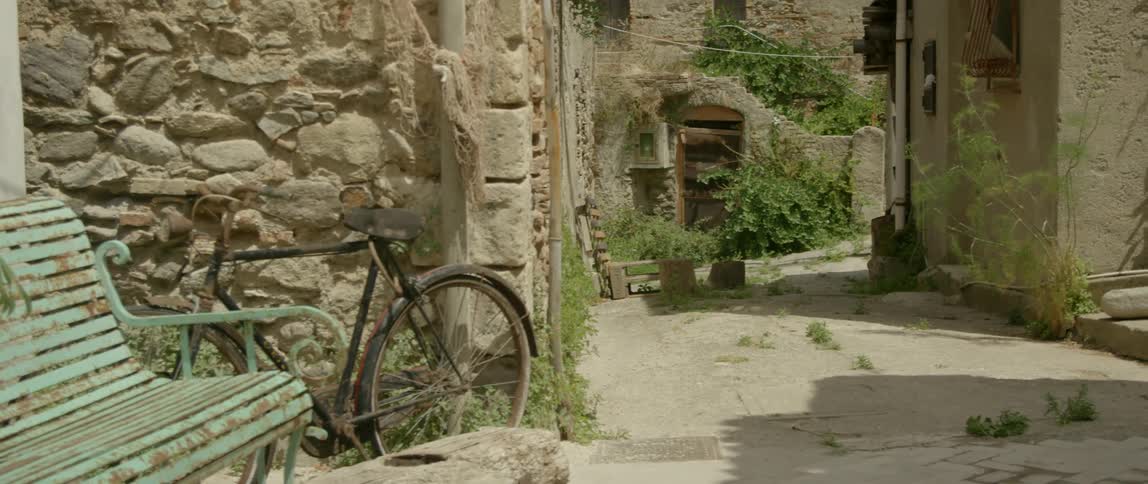 A bike is parked against a stone wall