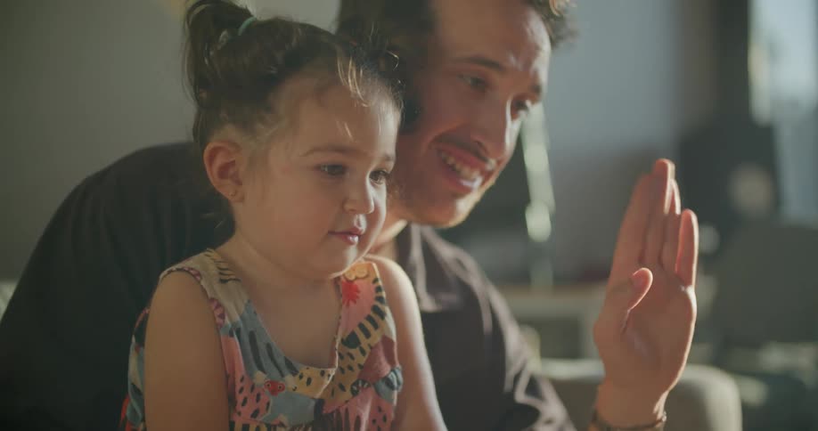 A father and daughter talking and waving at someone
