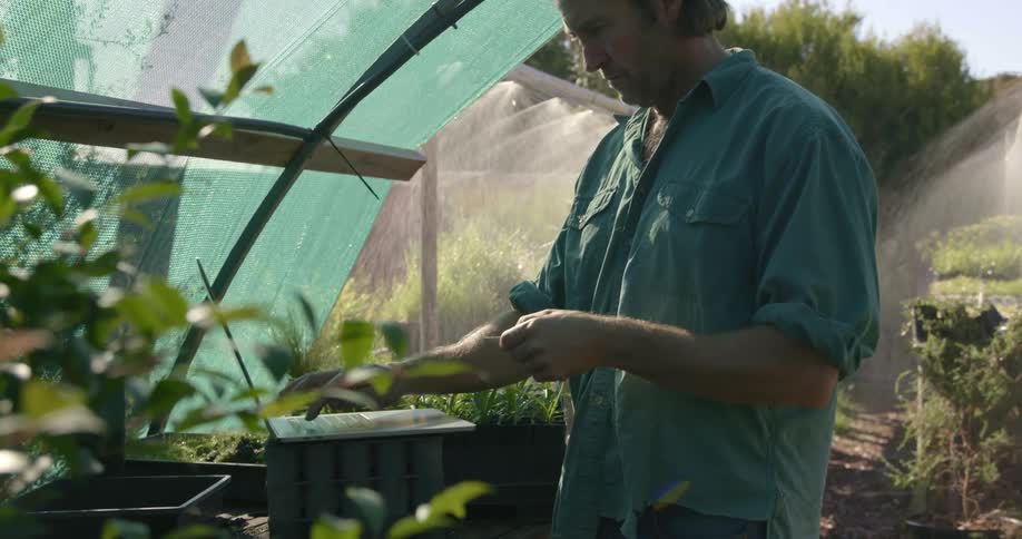 A man uses a laptop in a garden