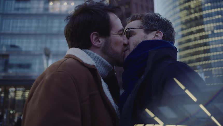 Two guys kissing in a city