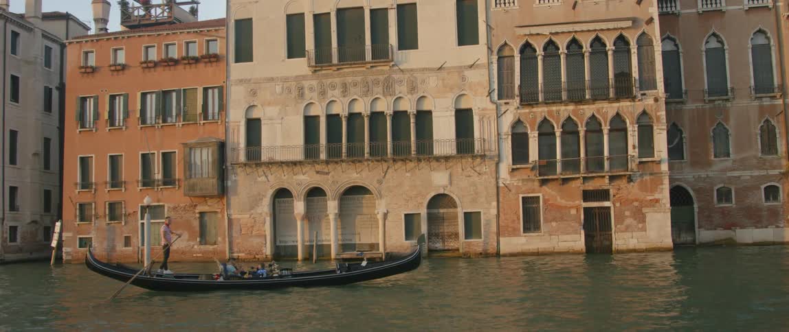 A gondola filled with people passing some buildings