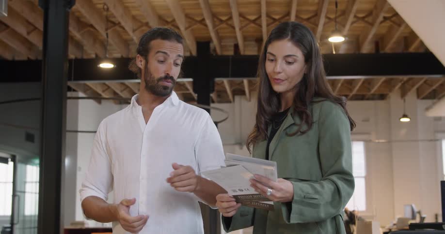 A man and woman looking over some papers in an office