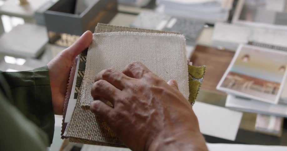 A man and woman go through a stack of fabric samples for redecorating