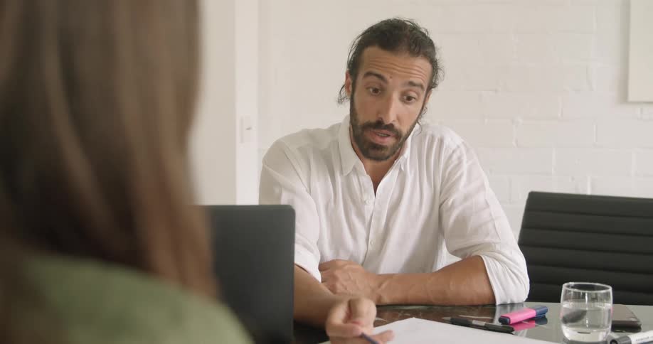 A man is talking and pointing to some papers