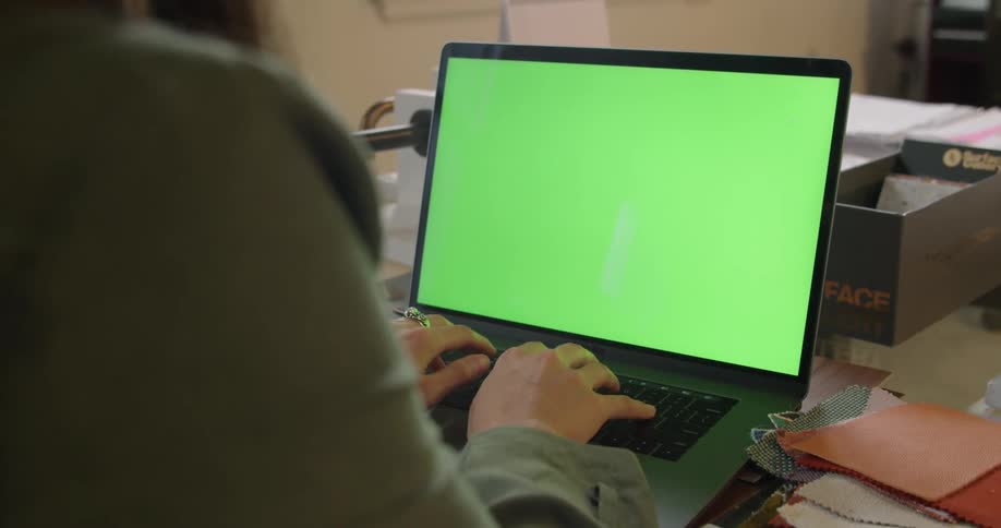 A woman is typing on her laptop