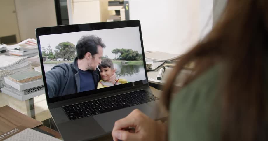 A mother is video chatting with her husband and son