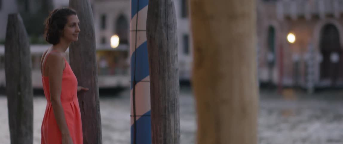 A woman is standing by the edge of a pier