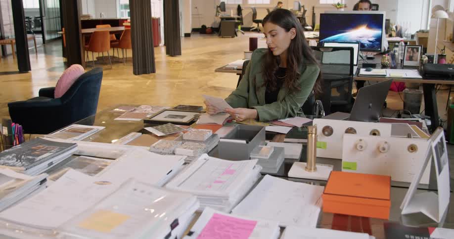 Woman sitting at a desk in the office checks samples of products