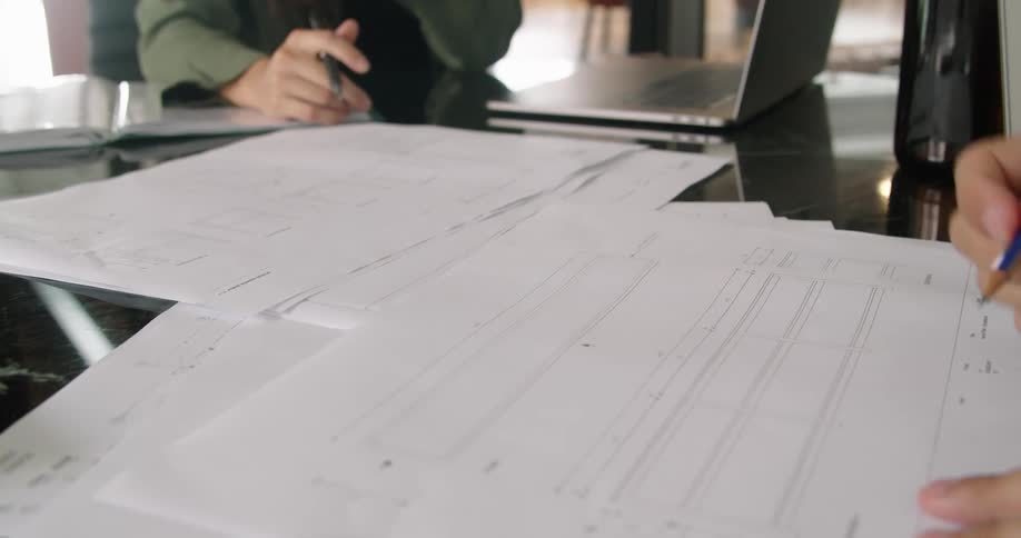 Two workers drawing on a blueprint