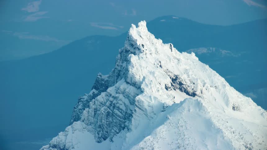 Blue hour zoomed in shot of rime ice clinging to the rocks of Mount Washington deep in the Cascade Mountains near Bend, Oregon in winter from high above earth